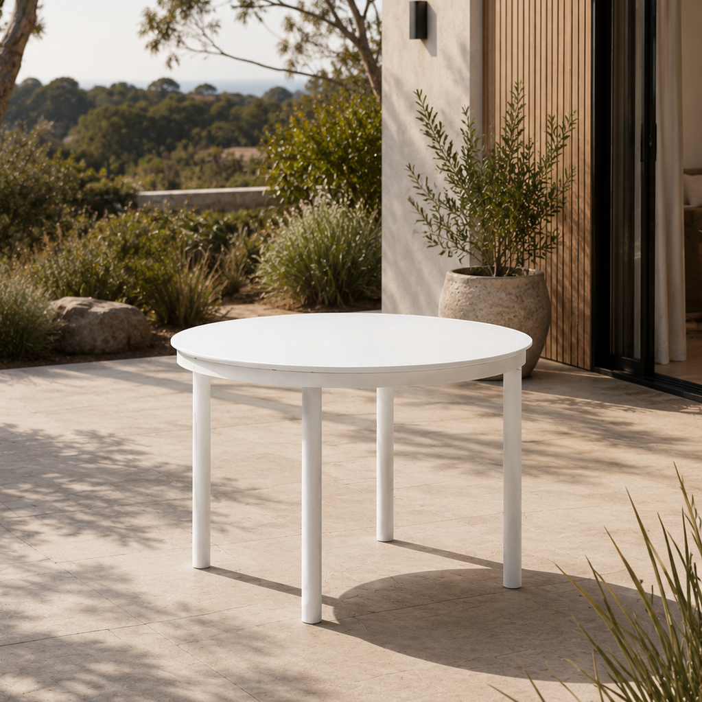 White round table on a patio with a scenic view and building in the background